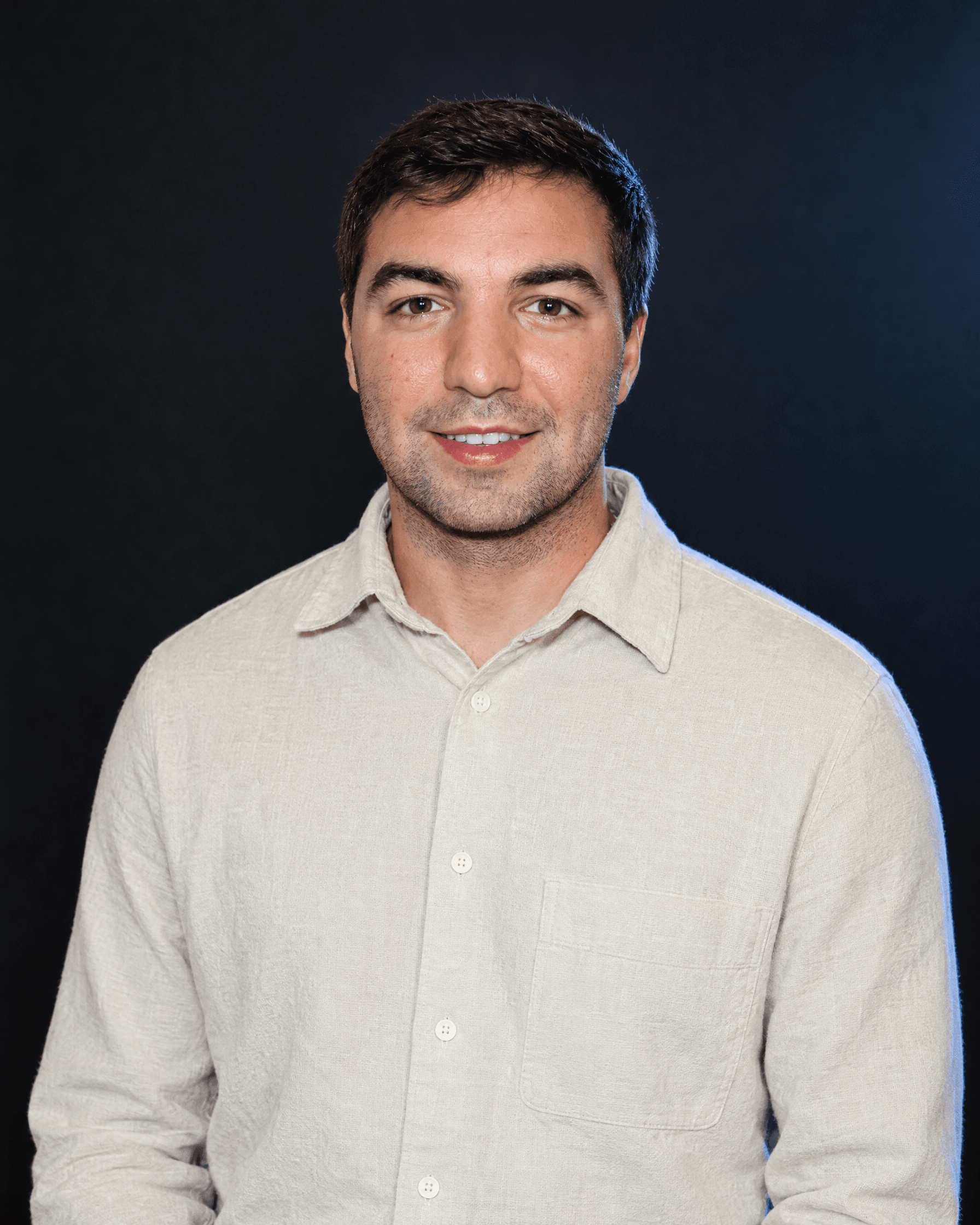 Bobby Neishman in an ivory shirt against a dark studio background